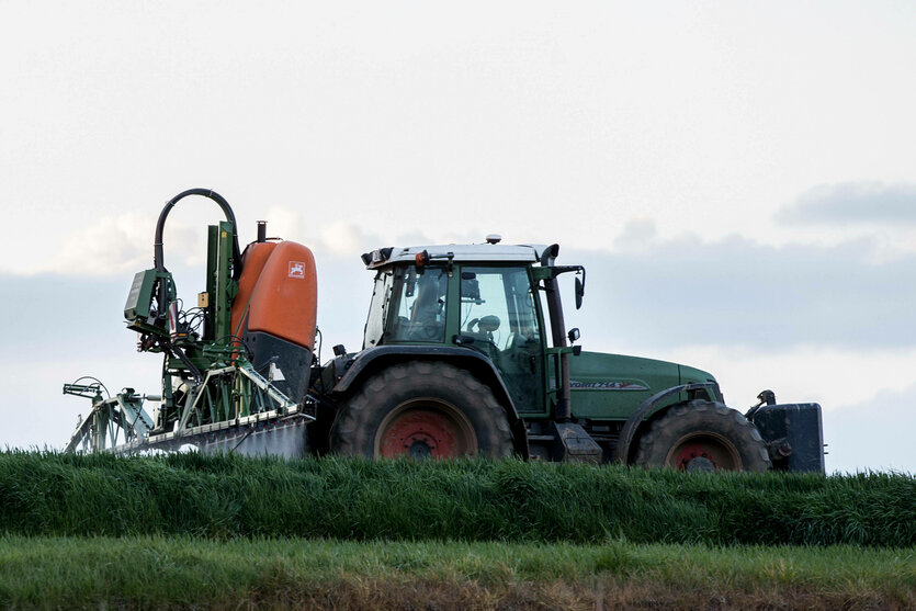 Ein Landwirt bringt mit seinem Traktor und einer großen Pflanzenschutzspritze ein hochwirksames Pflanzenschutzmittel auf das Feld aus. Symbolbild