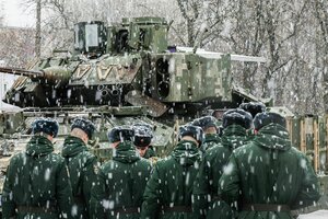 Russische Soldaten stehen bei starkem Schneefall vor einem Kampfpanzer