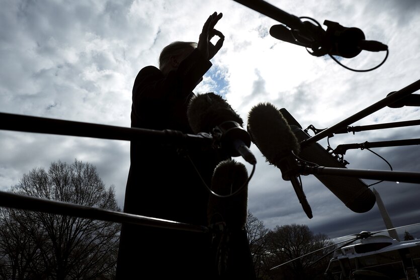 Silhouette von Donald Trump hinter Mikrofonen