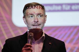 Christian Lindner, FDP, spricht auf einer Veranstalltung und hat die Worte Mann und Freiheit in sein Gesicht projeziert