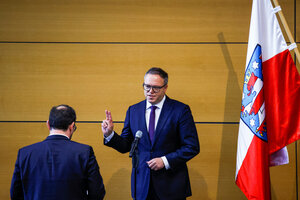 Mario Voigt hebt zwei Finger zum Schwur, neben ihm eine Flagge Thüringens