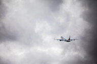 Ein Flugzeug steigt in den wolkenverhangenen Himmel