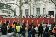 Vermummte vor einer roten Wand mit der Aufschrift "Nazizentrum dichtmachen", dahinter die Villa der Ghibellinia-Leipzig