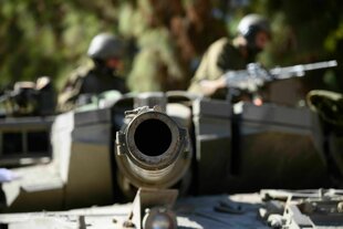 Ein Kanonenrohr und zwei Soldaten im Hintergrund