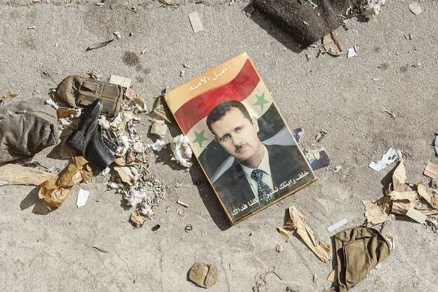 Ein Foto von Baschar Al-Assad liegt zwischen Müll auf dem Asphalt