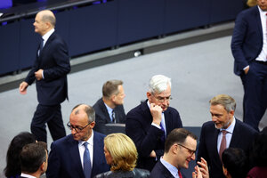 Im Bundestag stehen unter anderem Friedrich Merz und Christian Lindner in einem Pulk von Abgeordneten. Bundeskanzler Scholz läuft im Hintergrund alleine an der Gruppe vorbei.