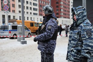 Zwei Polizisten in Tarnfleckuniformen stehen auf einer Straße in Moskau