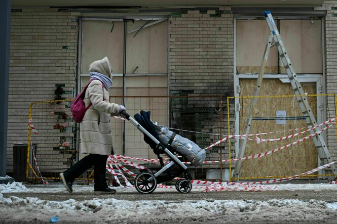 Eine Frau mit Kinderwagen geht am Tatort des Mordes vorbei