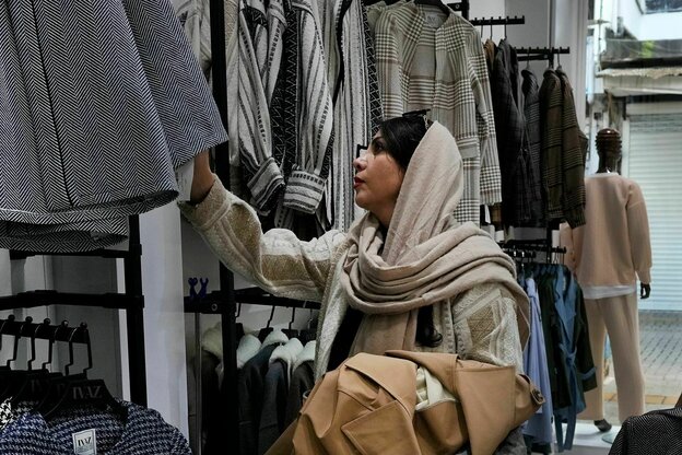 Eine Frau mit Kopftuch beim Kleidung shoppen