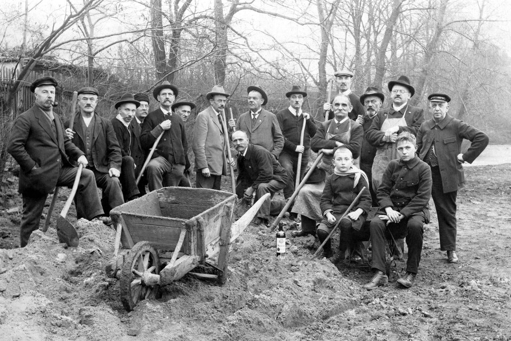 Eine historische Gruppenaufnahme von Bauarbeitern mit ihren Spaten