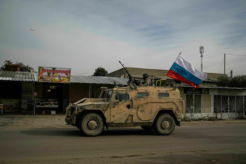 Ein Militärfahrzeug mit russischer Fahne fährt auf einer Straße in Syrien