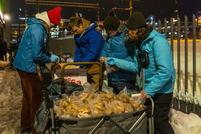 Vier Personen packen Brot in Plastiktüten