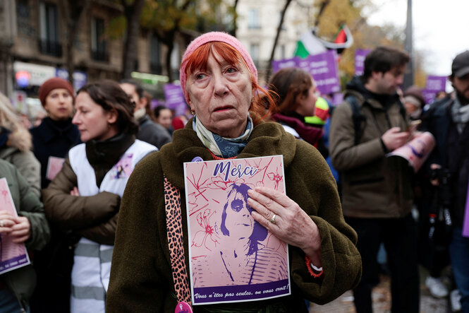 Eine Frau hält eine Plakat mit dem Konterfei von Gisel pelicot und dem Wort "Merci"