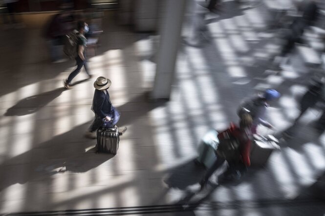 Menschen mit Koffern gehen durch einen bahnhof