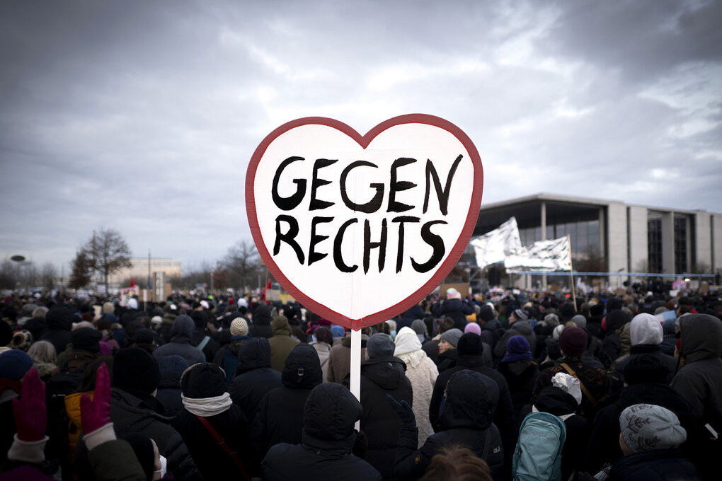 Eine Menschenmenge, jemand trägt ein Plakat in Herzform darauf steht "Gegen Rechts"