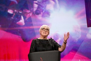 Claudia Roth steht auf einer Bühne und redet