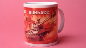 Ein Kaffeebecher, auf dem ein russischer Panzer aufgedruckt ist und die Aufschrift 