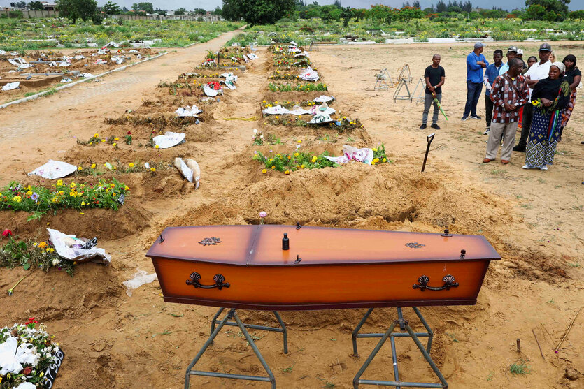 Menschen stehen auf einem Friedhof