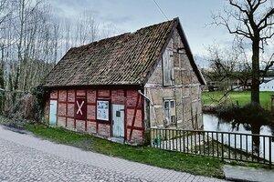 an einer Fachwerkkate hängt ein pink-gelbes 