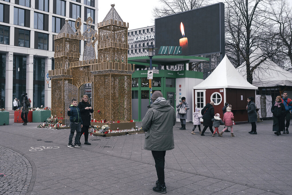 Zzene auf dem geschlossenen Weihnachtsmarkt in magdeburg, auf einem großen Bildschirm sieht man eine brennende Kerze