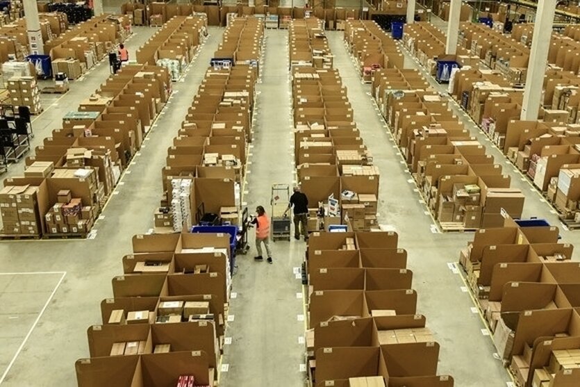 Ein Blick von oben in die Amazon-Logistikhalle in Rheinberg, in den Gängen sind ein paar Mitarbeiter*innen zu sehen