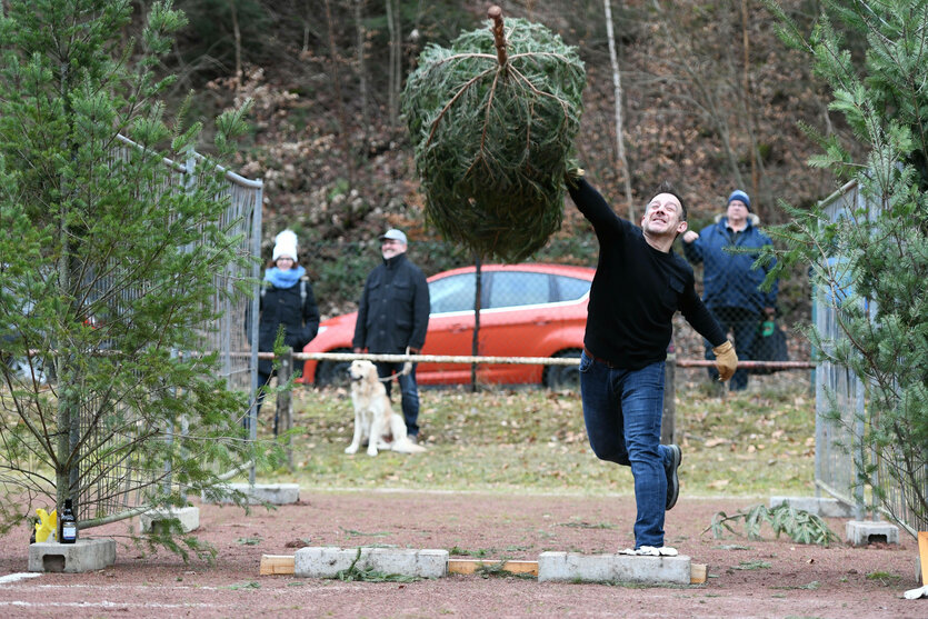 Ein Mann beim Weihnachtsbaumweitwurf