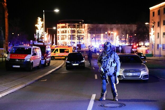 Ein bewaffneter und vermummter polizist steht auf einer Straße