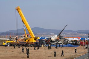 Feuerwehrleute und Mitglieder eines Rettungsteams in der Nähe des Wracks