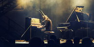 Pianist Lambert sitzt mit Maske am Klavier im Nebel