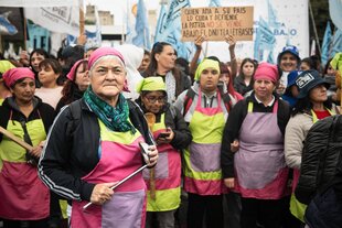 Menschen in bunter Kleidung mit Anti-Milei-Plakaten