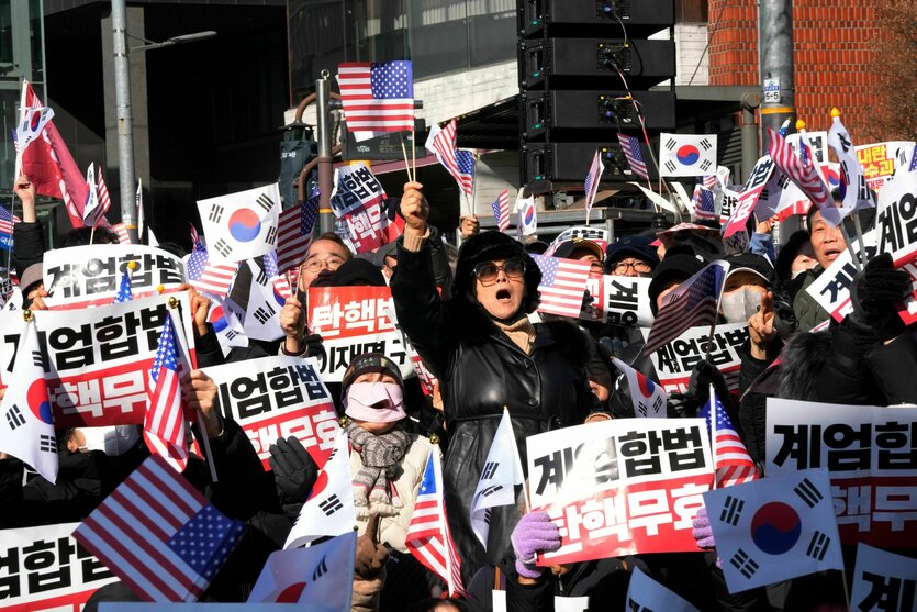 Koreaner protestieren in dicken Wintersachen und mit Plakaten gegen den Haftbefehl gegen den Präsidenten