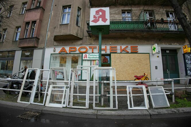 Fensterrahmen mit kaputten Scheiben vor einer Apotheke