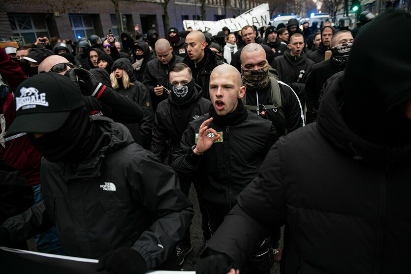 Neonazis bei einer Demo in Berlin, eine Glatze zeigt die "White-Power"-Geste