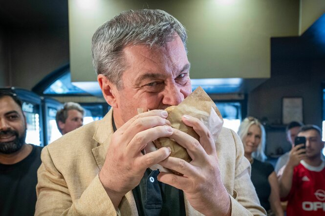 Markus Söder beißt herzhaft in einen Döner, den er mit beiden Händen fest umklammert