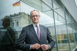 Friedrich Merz knöpft sich das Jackett zu