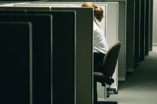 Eine Frau sitzt alleine in einem Büro