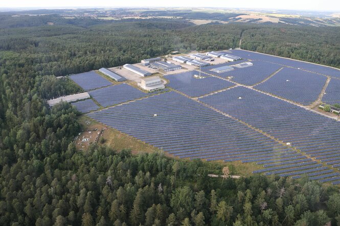 Ein Solarfeld ist an einer Waldlichtung zu sehen.