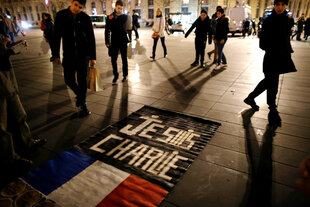 Auf einem Platz in Paris liegt ein Banner mit der Aufschrift „Je suis Charlie“