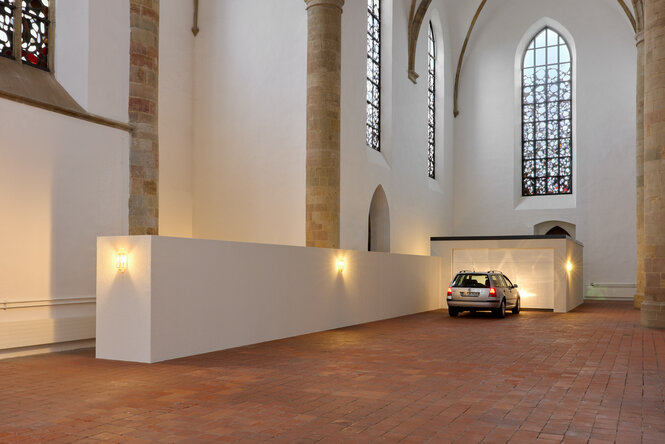 Kunstinstallation mit einer Garageneinfahrt samt VW in einer gotischen Kirche