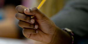 Ein Mädchen hält einen Bleistift in der Hand