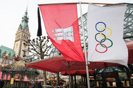 Eine Hamburg- und eine Olympia-Flagge wehen vor dem Hamburger Rathaus