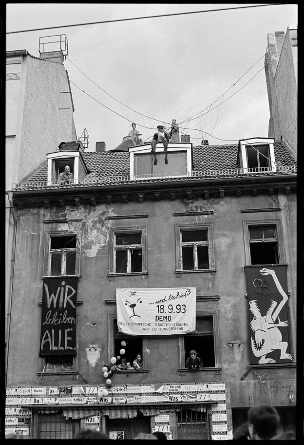 Fassade eine Hauses mit Transparenten, auf dem Dach eine Band