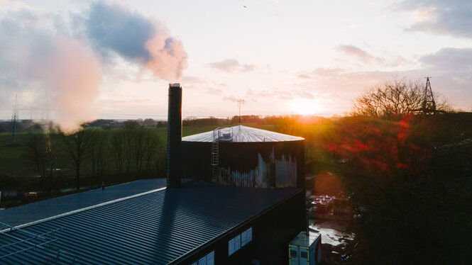 Blick über eine Biomethananlage im Sonnenuntergang.