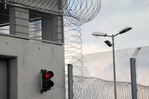 Gefängnisbau mit Stacheldraht, Zaun und Ampel