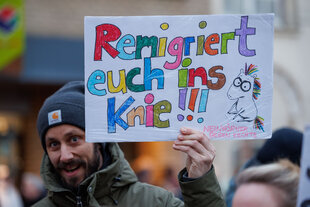 Ein Plakat "Remigriert euch ins Knie!" ist bei einer Demonstration gegen Rechtsextremismus auf einem Plakat zu sehen