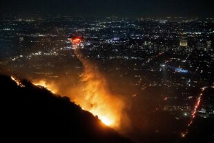 Ein Löschhubschauber wirft Wasser über den Bränden in den Hollywood Hills ab