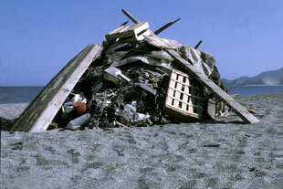 Unrat wie zB Obstkisten und Palletten, aufgetürmt als Kunstinstallation: Hans Haackes "Denkmal der Strandverschmutzung" (1970)