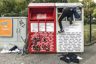 Eine Person klettert in einen Altkleidercontainer.