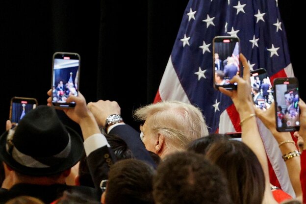 Viele Personen fotografieren Trump bei einer Veranstaltung.