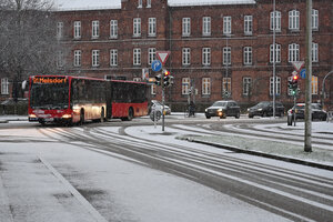 Ein Bus fährt auf einer verschneiten Straße in der Kieler Innenstadt